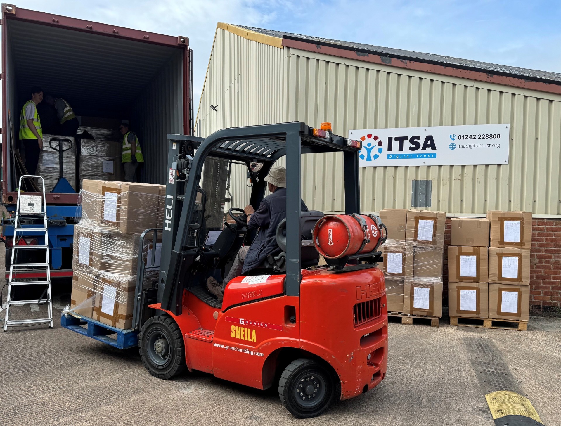 a truck being loaded with boxes of computers 